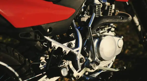 Silnik motocykla z czerwonym siedzeniem. Zastanawiasz się, świece irydowe co ile wymiana?