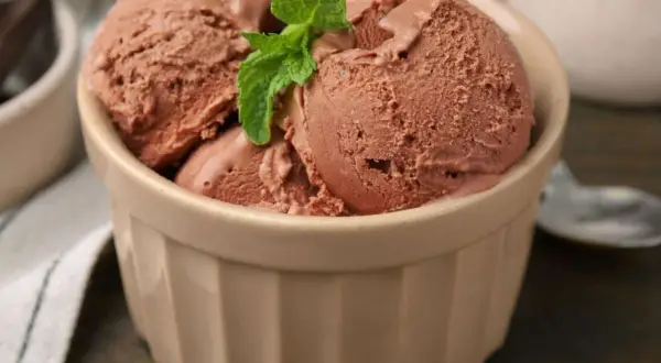 Schokoladeneis in einer Schale, garniert mit Minze. Perfekt für alle, die gerne Eis selber machen und den Sommer genießen.
