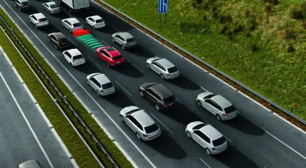 Na autostradzie samochody jadą w kolumnie, stosując zasadę ograniczonego zaufania. Czerwony samochód ostrzega o zbliżaniu się do innych pojazdów.