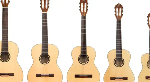 Rząd gitar klasycznych i akustycznych. Zobacz, czym się różni gitara klasyczna od akustycznej, porównując ich rozmiary i detale.
