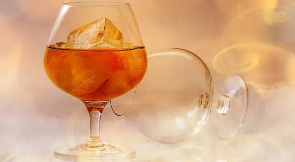 Szklanka brandy z lodem, obok pusta szklanka. Idealne do delektowania się smakiem.
