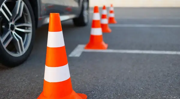 Pomarańczowe pachołki wyznaczają trasę na placu manewrowym. B+E to kategoria prawa jazdy, którą można zdobyć, ćwicząc na takim torze.