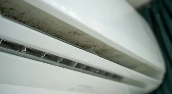 Brudny panel klimatyzacji domowej, widoczny nalot pleśni. Czas na czyszczenie klimatyzacji domowej, by zapewnić czyste powietrze.