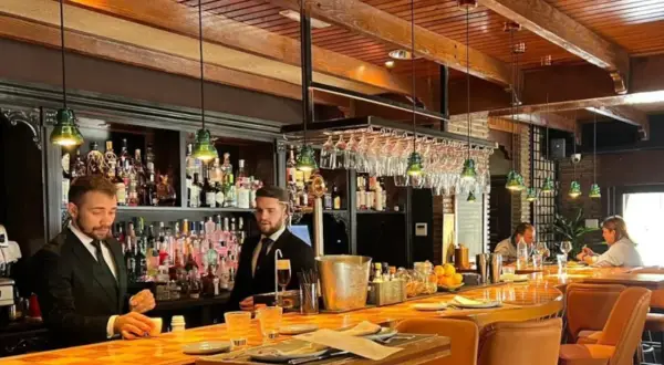 Banqueros sirviendo en uno de los restaurantes el ejido, con un ambiente acogedor y una barra de madera pulida.