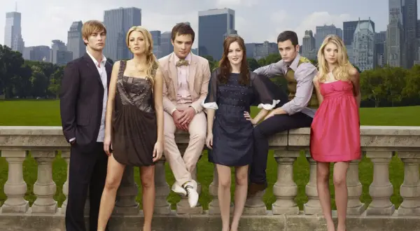 Die Hauptbesetzung von Gossip Girl posiert vor der Skyline von New York.