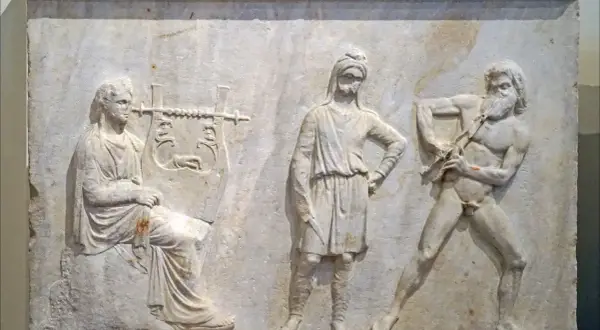 Bas-relief antique : une femme joue de la lyre, un homme au centre, et un homme nu jouant de la cithare, symbole Apollon.
