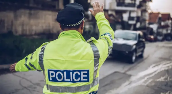 Policjant w odblaskowej kamizelce kieruje ruchem. Może to być kontrola drogowa, która przypomni o odsetkach za niezapłacony mandat w Niemczech.