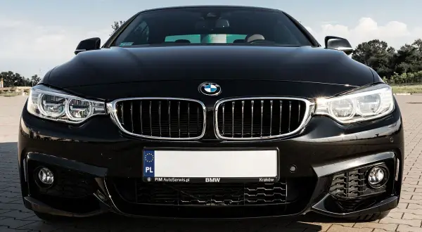 Czarny BMW F32 435i z błyszczącą atrapą chłodnicy i ostrymi reflektorami, gotowy do jazdy po krakowskich ulicach.