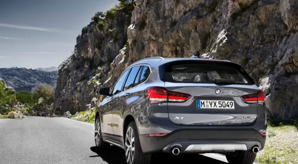 Szary BMW X1 na górskiej drodze. Sprawdź aktualną bmw x1 cena i wybierz się na przygodę!