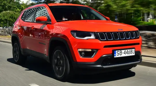 Pomarańczowy Jeep Compass w ruchu. Czy warto kupić ten SUV? Stylowy wygląd i komfort jazdy.