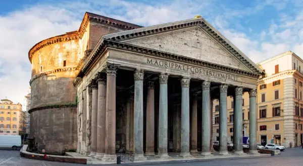 La basilica di Santa Maria ad Martyres, il Pantheon, con il suo portico colonnato e la cupola imponente, si erge maestosa sotto un cielo azzurro.