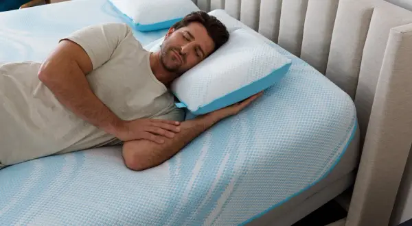 Man sleeping peacefully on a Tempur-Pedic pillow, enjoying the comfort and subtle, fresh tempurpedic pillow smell.