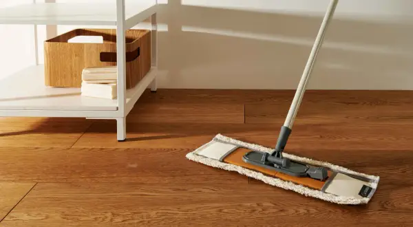 Mocio pronto per pulire pavimento marmo molto sporco. Sulla mensola, una cesta in legno e saponi.