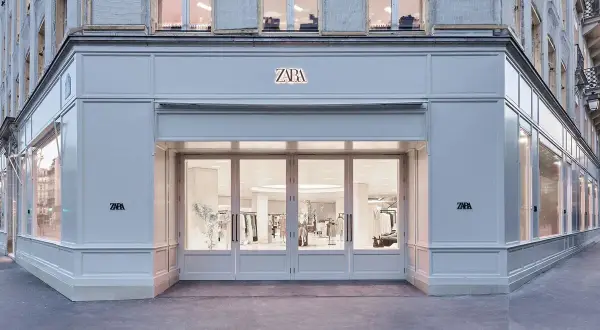 Façade d'un magasin Zara, une des marques d'Inditex, avec ses grandes vitrines et son entrée lumineuse.