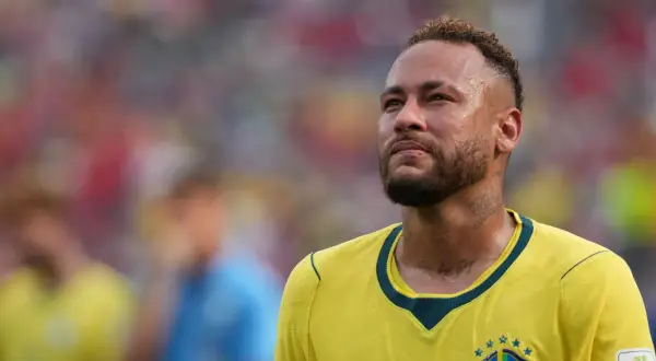 Neymar, w wieku 31 lat, w żółtej koszulce reprezentacji Brazylii, zamyślony na boisku.