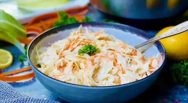 Frischer Krautsalat mit Karotten, perfekt für jedes coleslaw rezept. Ein Löffel liegt bereit.