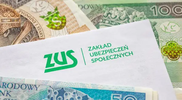 Koperta ZUS na tle polskich banknotów. Pytanie: ile czasu ma pracodawca na wypłacenie chorobowego?