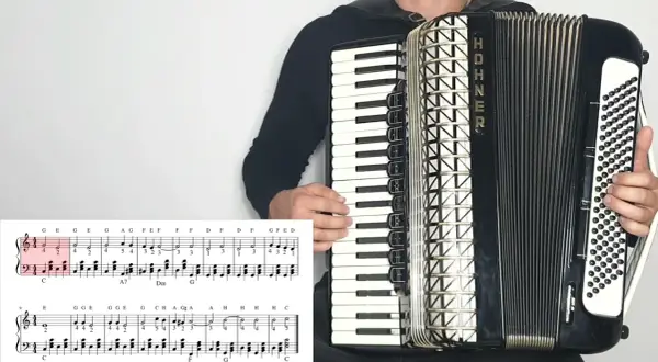 Akordeonista gra znane utwory na akordeon, widoczna partytura z nutami.