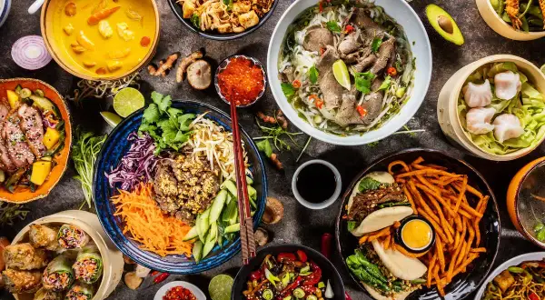 Vielfalt an asiatischem Essen: Pho, Frühlingsrollen, gedämpfte Teigtaschen, gebratene Nudeln und mehr.