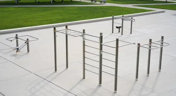 Un parc de street workout avec barres de traction, échelles et agrès pour un entraînement en plein air.