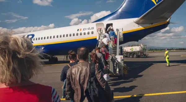 Pasażerowie wsiadają do samolotu Ryanair. Zastanawiasz się, ile kosztuje odprawa na lotnisku Ryanair?
