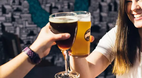 Dwie kobiety wznoszą toast piwem. Jedno ciemne, drugie jasne. Czy to kwarta piwa?
