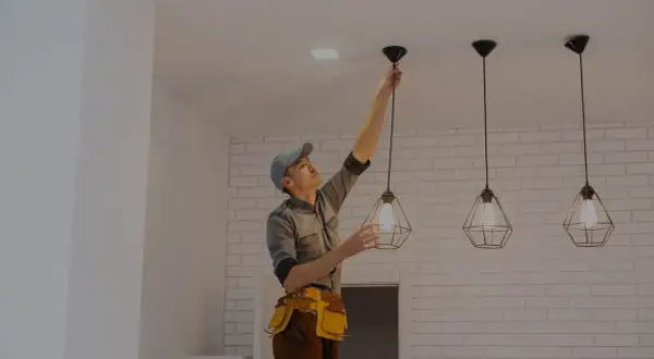 Elektryk montuje lampę sufitową. Sprawdź, jaka jest cena montażu lampy sufitowej.