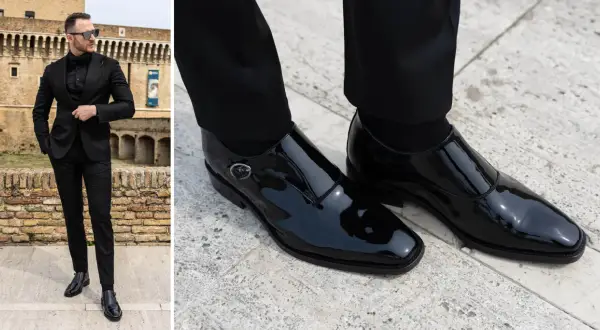 Uomo elegante in abito nero con camicia e papillon, indossa lucidi mocassini con fibbia.