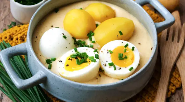 Senfeier rezept: Ein deftiger Eintopf mit Kartoffeln und halbierten Eiern in cremiger Senfsauce, garniert mit Schnittlauch.