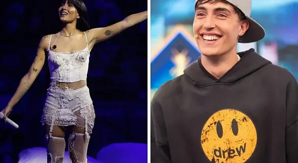 Aitana canta en el escenario con un traje blanco y su novio, Sebastián Yatra, sonríe con una gorra gris.