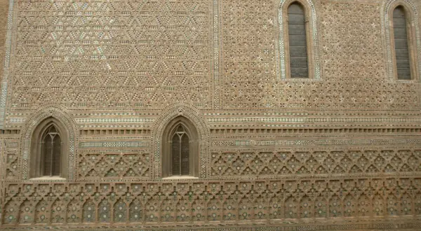 Detalle de la fachada de la parroquieta de la Seo, con intrincados mosaicos de ladrillo y azulejos formando patrones geométricos y florales.