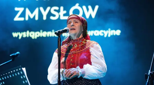 Julia Doszna w tradycyjnym stroju, śpiewająca na scenie.