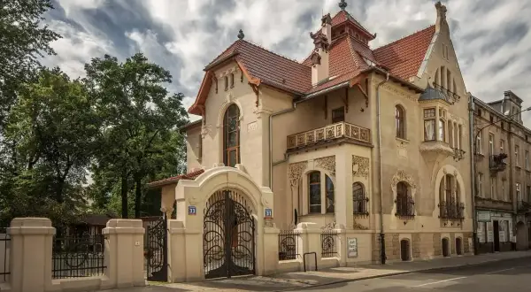 Elegancka willa w stylu secesja Młoda Polska, z bogatymi zdobieniami i kutą bramą.