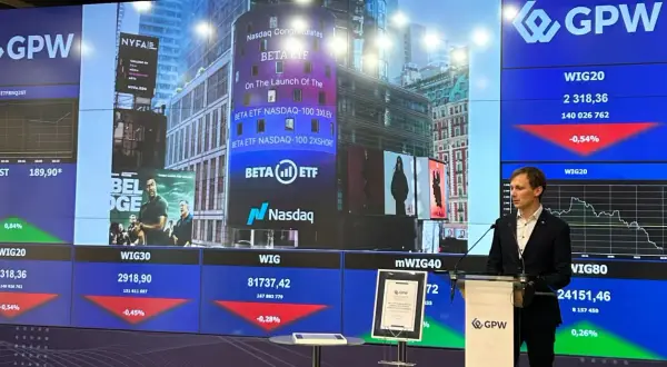 Prezentacja na GPW z informacjami o ETFach, w tym o BETA ETF NASDAQ-100. W tle widać ekrany z danymi giełdowymi.