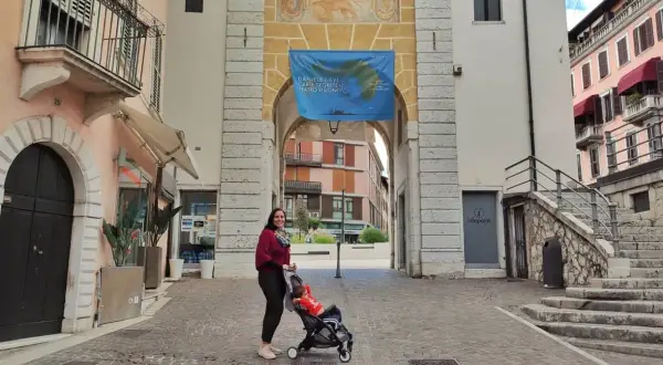 Donna con passeggino sotto un arco a Salò, tra le tante cose da fare.