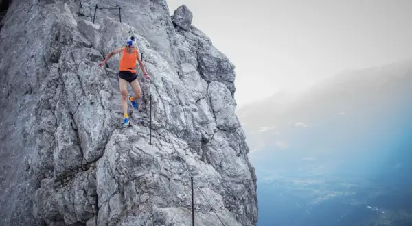 Anton Palzer bezwingt den Watzmann, ein Trailrunner in Aktion auf steilem Fels mit Sicherungsseil.