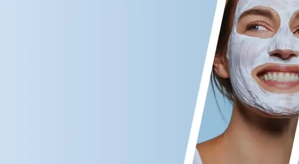 Mujer sonriente con mascarilla de arcilla blanca, disfrutando de un momento de cuidado facial.