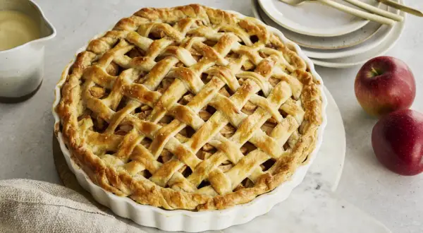 Goldbrauner Apfelkuchen mit Gittermuster, perfekt für Ihr nächstes apple pie rezept. Dazu passt Vanillesauce.