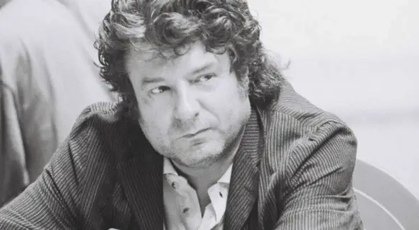 Enrique Morente joven, con su melena rizada y mirada pensativa, viste chaqueta de rayas.