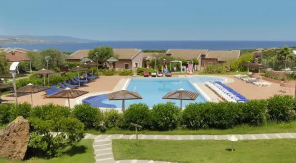 Villaggio con piscina e lettini, vista mare. Una **cala rosa** al **mattinata** ideale per rilassarsi.