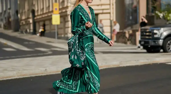 Eleganckie sukienki maskujące brzuch na wesele, w tym zielona, wzorzysta kreacja z falbanami, idealna na letnie przyjęcie.