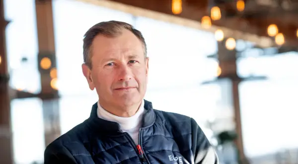 SkiStar VD, Stefan Söderberg, bär en blå dunjacka över en vit polotröja. Bakgrunden är suddig med ljus och trädetaljer.