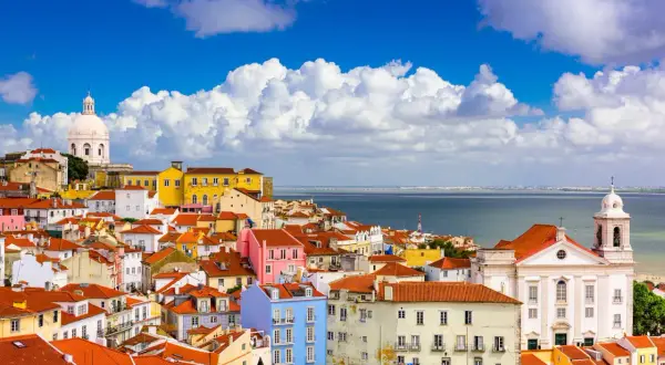 Färgglada hus i Lissabon under en blå himmel med moln. Perfekt lissabon temperatur för att utforska staden.