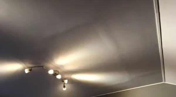Taket är gipsat och skarvarna är spacklade. En taklampa med flera spotlights lyser upp rummet.