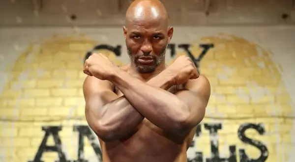 Bernard Hopkins, the legendary boxer, stands with arms crossed, a determined look on his face. He's a true inspiration, a master of his craft, and a great trainer.