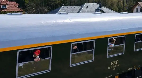 Pociąg retro PKP z pasażerami wyglądającymi przez okna. Sprawdzam pociąg retro rozkład jazdy.