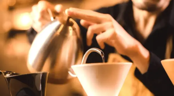 Barista häller upp varmt vatten för kaffe. Undrar hur hårt vatten har jag för att få bästa smak?