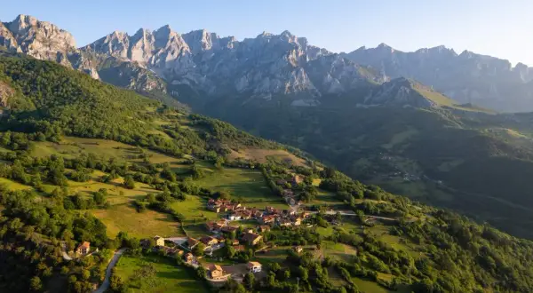 Un pueblo anidado en verdes colinas bajo los imponentes Picos de Europa. Descubre curiosidades de los Picos de Europa en este paisaje idílico.