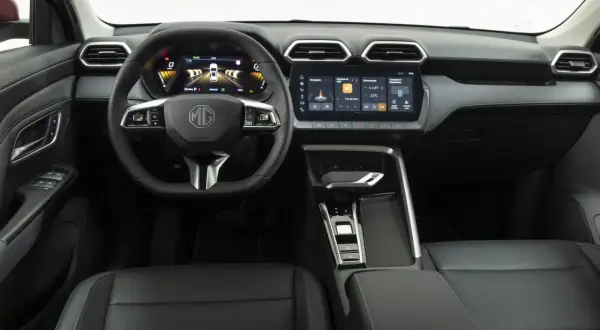 Interni moderni dell'MG ZS con volante multifunzione, cruscotto digitale e ampio touchscreen centrale.