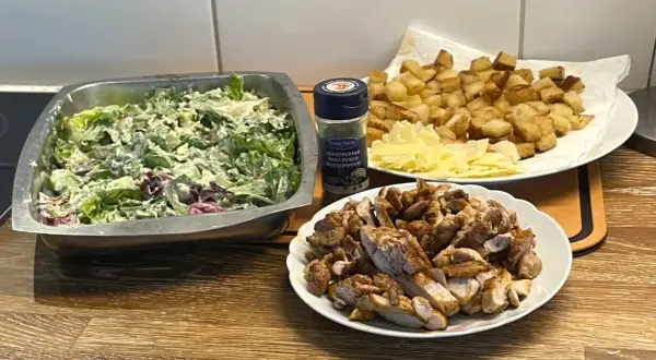Förberedelser för ett fantastiskt ceasarsallad recept: krispig sallad, stekt kyckling, krutonger och parmesan.
